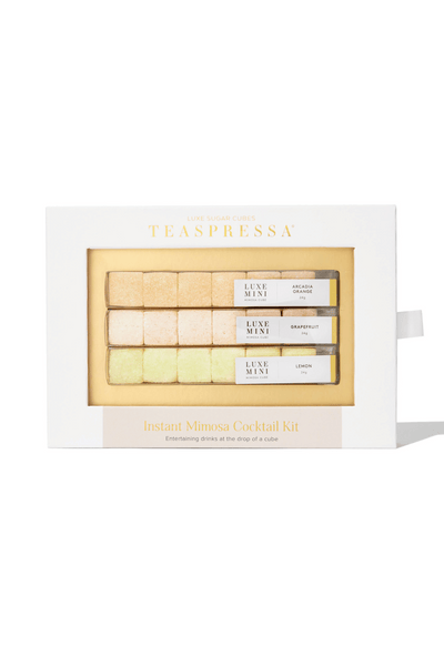 A packaged Instant Mimosa Kit by Teaspressa, containing yellow and beige sugar cubes in a white box with gold accents.