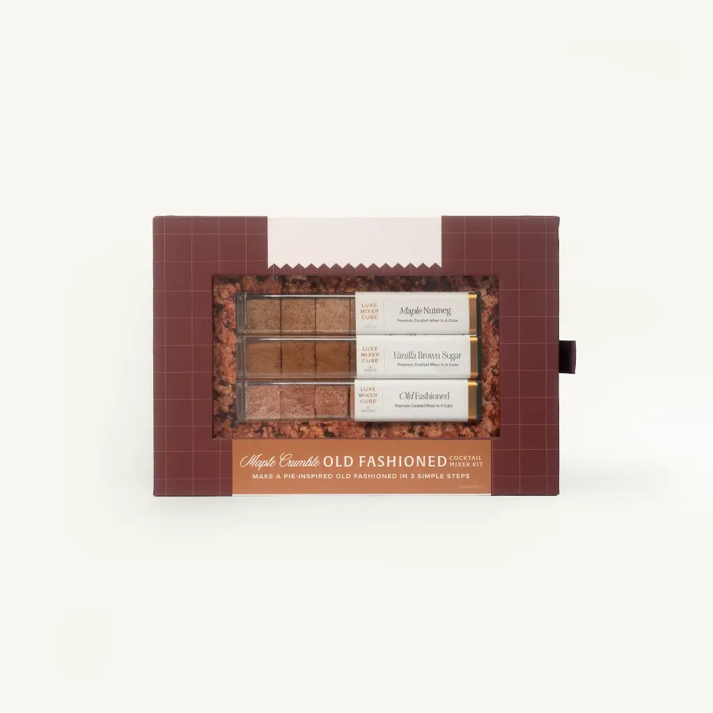 A boxed set of three maple syrup flavor options in a dark reddish-brown package with a clear window showing the brown syrups and labels reading Maple Starburst, Vanilla Bean Sugar, and Chile Hazelnut.