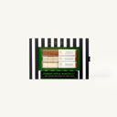 A boxed set of Poison Apple Martini ingredients displayed on a black-and-white striped card against a light gray background. The package contains multiple small glass bottles with visible spices and fillings, plus a green label area.