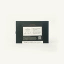 The back of a black rectangular box with printed white text and a small QR code, photographed against a plain white background.