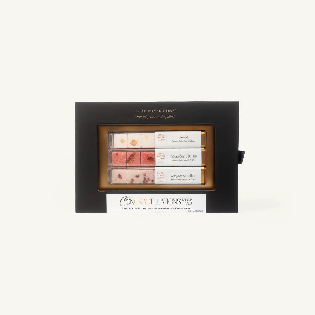 A gift box labeled Luxe Mixer Cube with three rows of cocktail mixer cubes in flavors: Peach Bellini, Strawberry Bellini, and Raspberry Bellini. The box has a Congra'D'tulations message on the front.