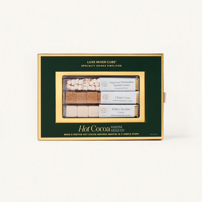 Hot cocoa mix set in a green box with gold accents on a white background