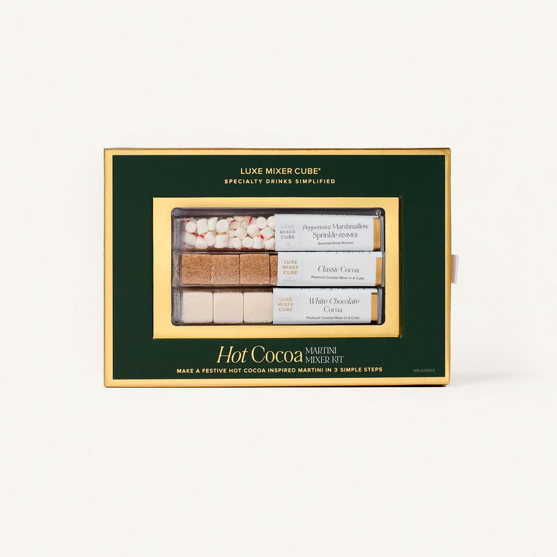 Hot cocoa mix set in a green box with gold accents on a white background