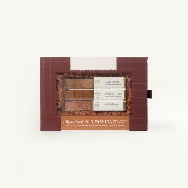 A boxed set of three maple syrup flavor options in a dark reddish-brown package with a clear window showing the brown syrups and labels reading Maple Starburst, Vanilla Bean Sugar, and Chile Hazelnut.