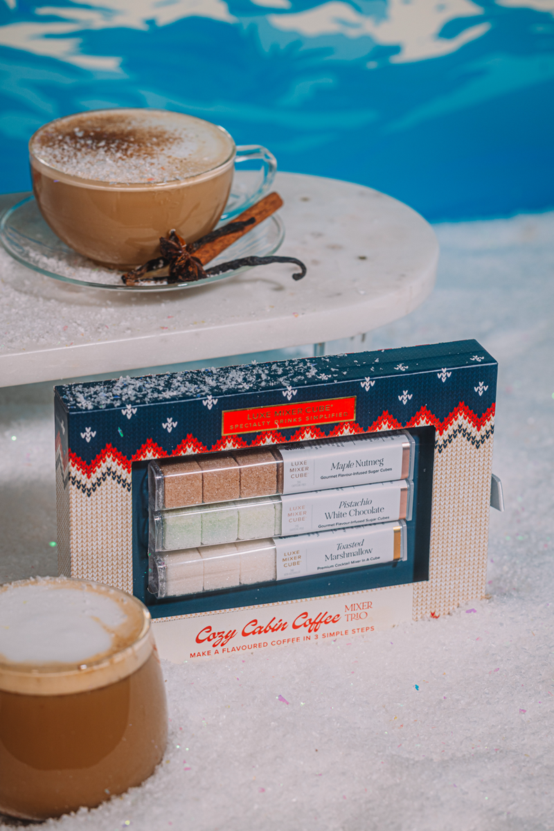 Cozy Cabin Coffee Mixer Trio with a two coffee cups on a snowy background