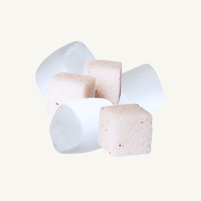 White and beige marshmallows on a light gray background