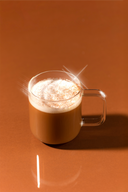 Glass mug with a hot beverage on a brown background